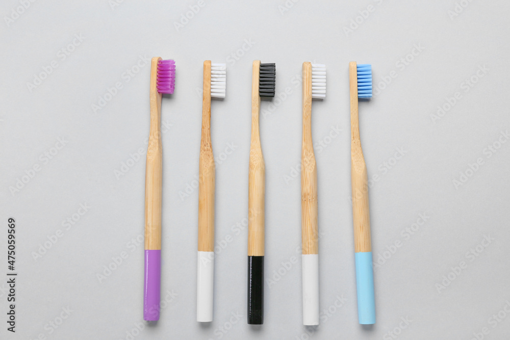 Different wooden toothbrushes on grey background Different wooden toothbrushes on grey background