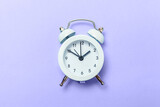 Vintage classic alarm clock colored in trendy color of year 2022 Very Peri background. Flat lay top view copy space. Inspired by using color 17-3938. Color of the year concept