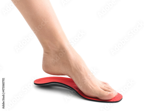 Female foot and red orthopedic insole on white background