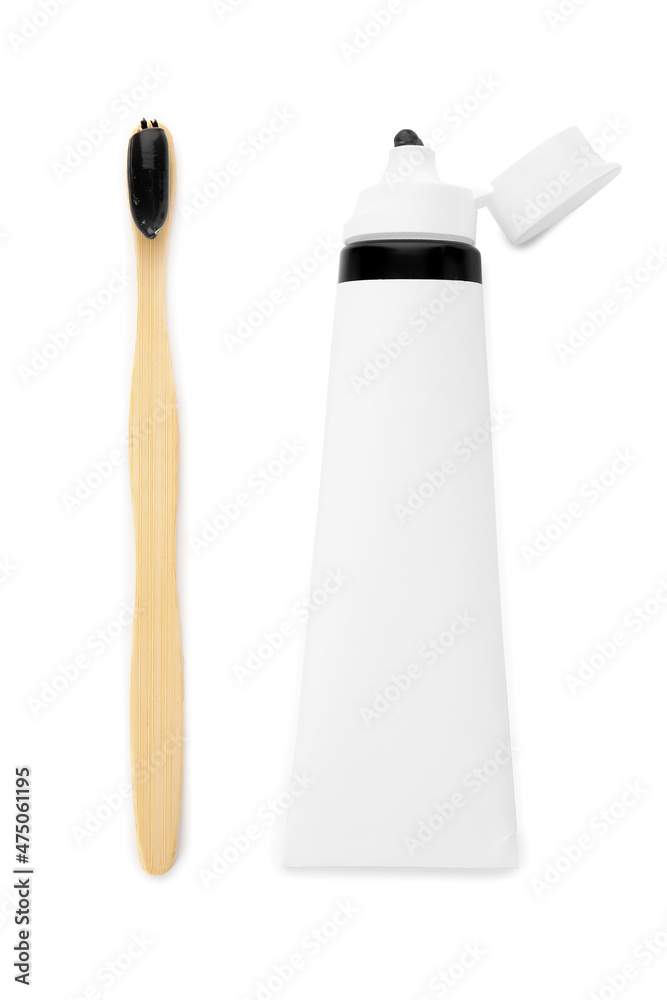 Tube with black tooth paste and brush on white background Tube with black tooth paste and brush on white background
