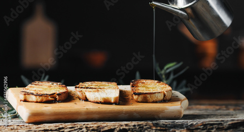 Fotografie hand pours olive oil on toast bread