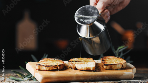 Obraz na plátně hand pours olive oil on toast bread