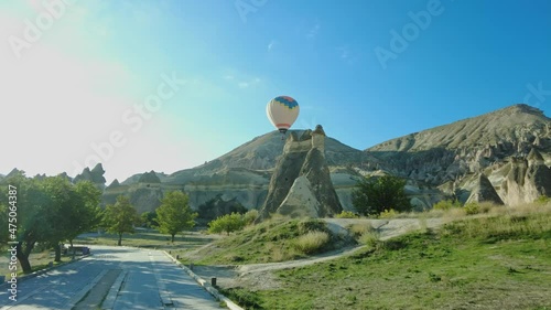 Pasabag Valley or Pasabaglari Open Air Museum and flying hot air balloon over fairy chimneys in Cappadocia, Turkey.