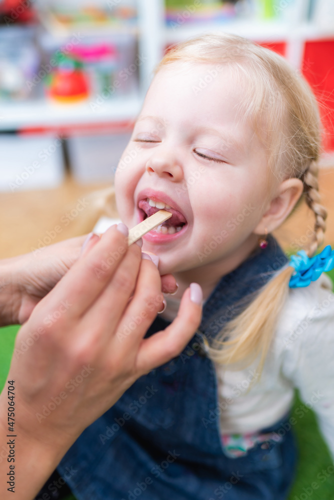Woman speech therapist helps little girl to correct her speech in her office Woman speech therapist helps little girl to correct her speech in her office