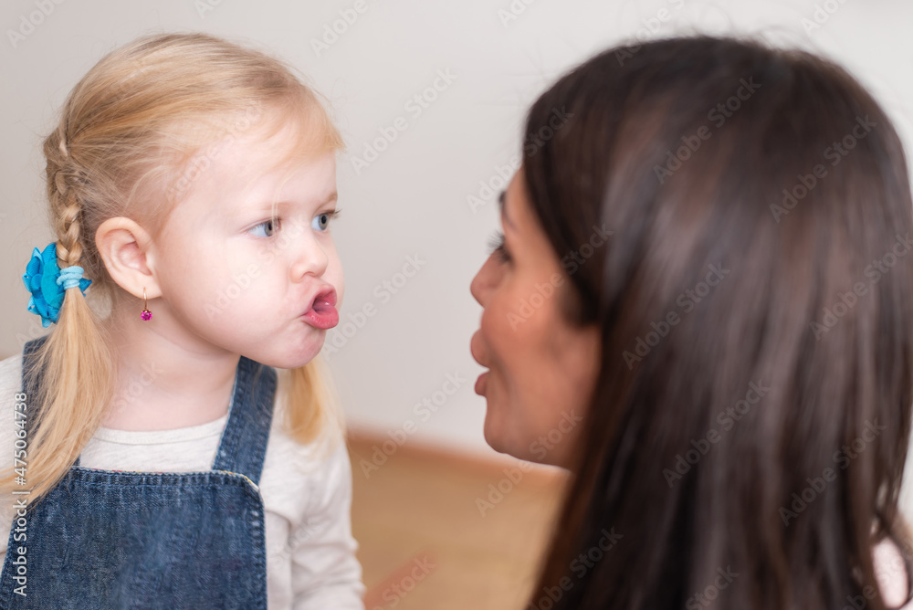 Woman speech therapist teaches a girl the correct pronunciation and literate speech Woman speech therapist teaches a girl the correct pronunciation and literate speech