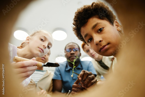 Low angle view of kids looking inside while doing experiments in class photo
