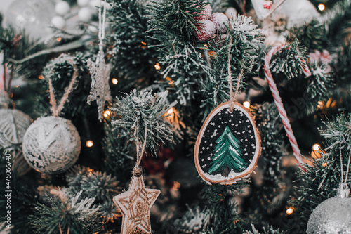 Close-up photo of wooden christmas ornament with handpainted christmas tree on wood slice photo