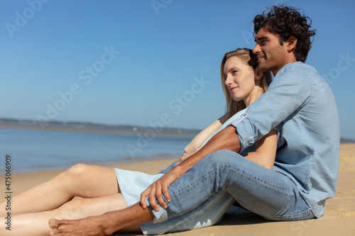 two friends seating on the beach together