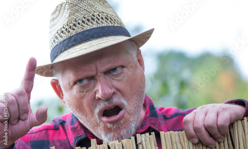 Konstfotografi Ein Mann steht böse schimpfend hinter einem Gartenzaun