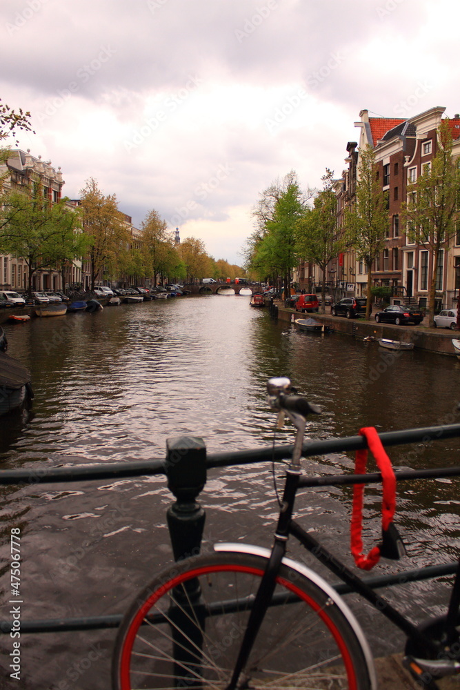 Beautiful view of the city of Amsterdam. Bicycles along the street on the bridge over the canal.