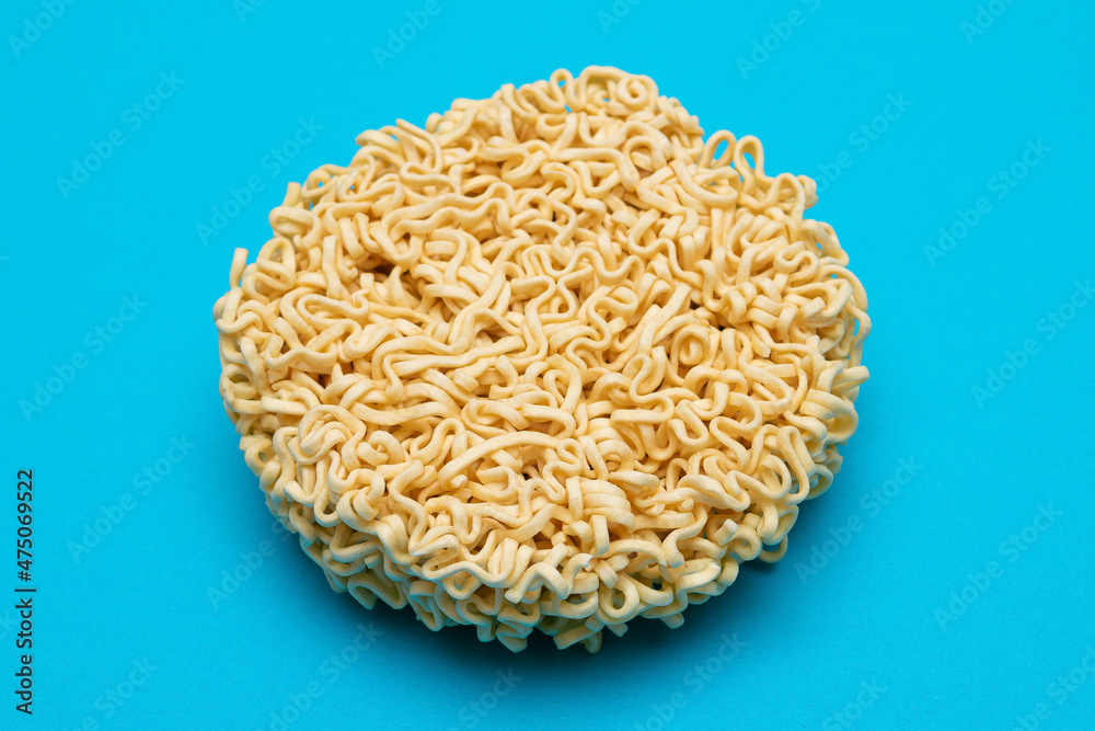 Uncooked Instant Noodles on Blue Background. Raw Pasta. Dry Asian Fast Food. Quick Lunch Uncooked Instant Noodles on Blue Background. Raw Pasta. Dry Asian Fast Food. Quick Lunch