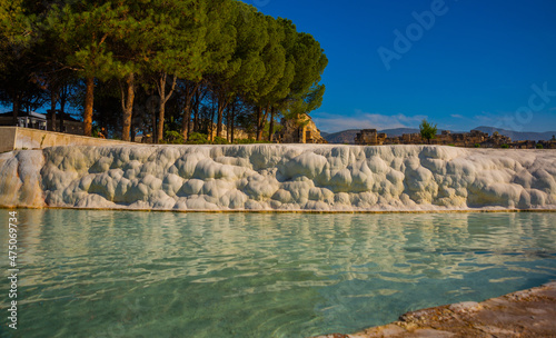 PAMUKKALE, TURKEY: White travertines and a pool with clear water in Pamukkale on a sunny day.