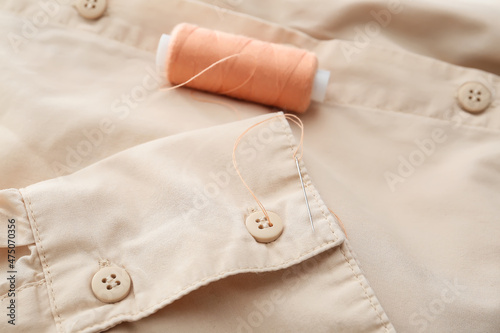 Closeup view of buttons and needle on shirt sleeve, closeup