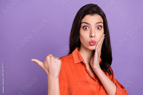 Portrait of attractive stunned girl showing copy space ad solution isolated over bright purple violet color background