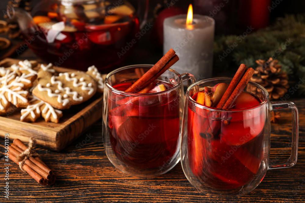 Glass cups of tasty fruit tea with cinnamon on wooden background Glass cups of tasty fruit tea with cinnamon on wooden background