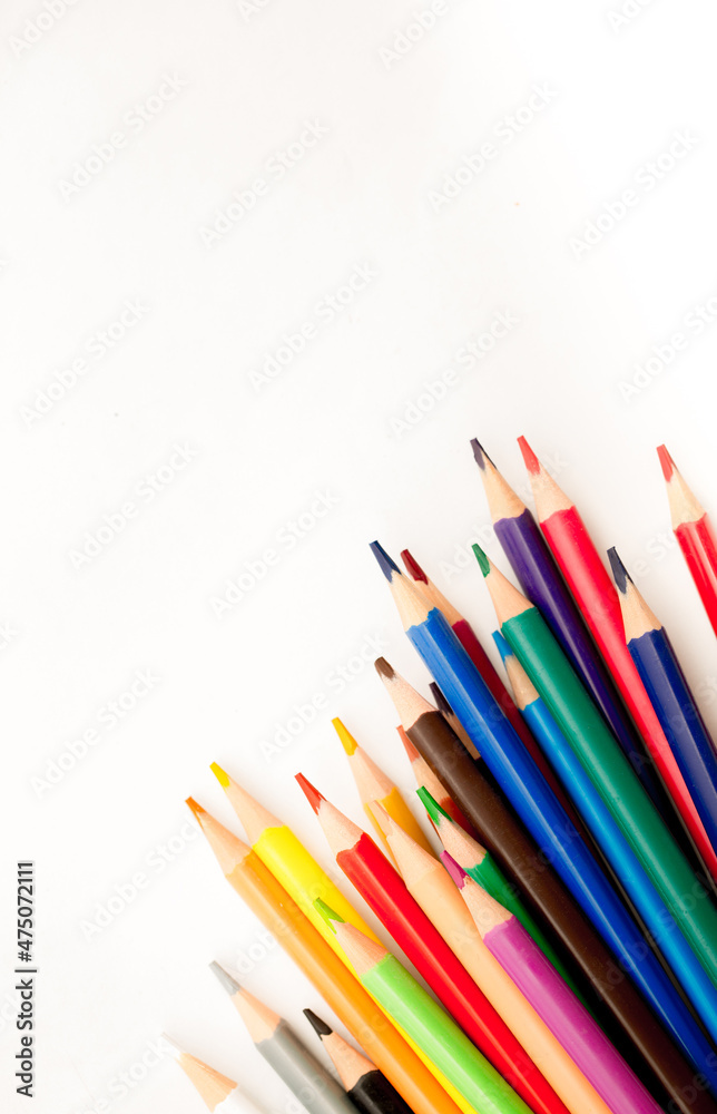 School stationery items. Creation Multicolored pencils on a blank white sheet. On a white background. Children's drawing, artist. School stationery items. Creation Multicolored pencils on a blank white sheet. On a white background. Children's drawing, artist.