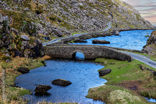 Stone Wishing Bridge over winding stream in green valley at Gap of Dunloe in Black Valley of Ring of Kerry  County Kerry  Ireland