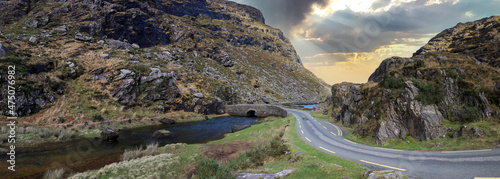 Fotografie Panoramic view of the stone Wishing Bridge over winding stream in green valley a