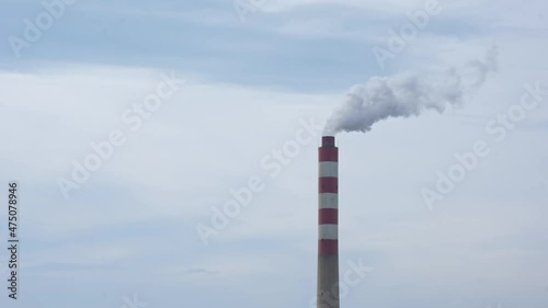 Factory chimney with smoke coming out. Factory pipe pollutes the air in an industrial area.