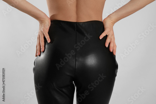 Foto Woman in sexy black leather pants on light background, closeup