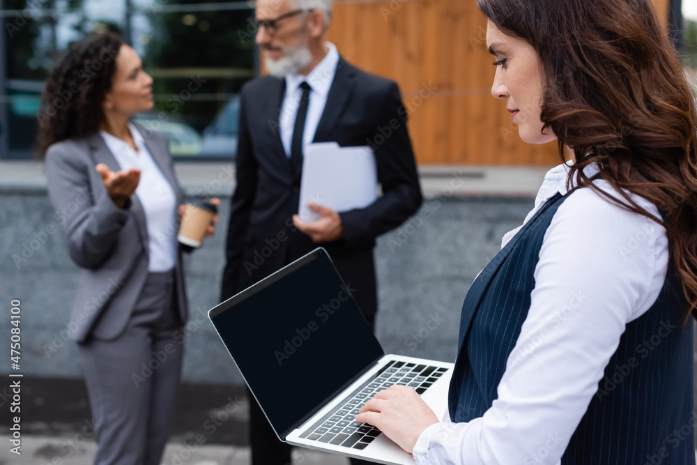 real estate agent using digital tablet near multiethnic business partners talking on blurred background real estate agent using digital tablet near multiethnic business partners talking on blurred background