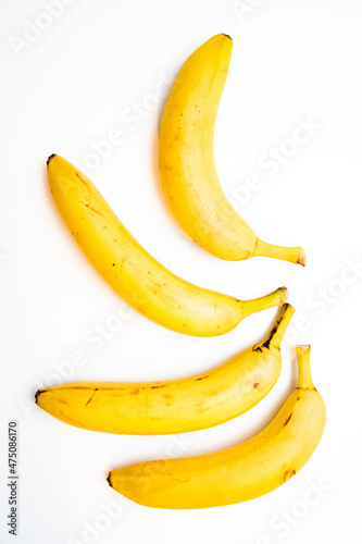 Bunch of yellow bananas laid on white background.