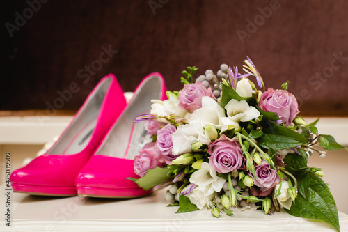 Wedding accessories: Bride's shoes, rings, boutonniere, and elegant wedding bouquet with tea roses, white dahlias and brunei 