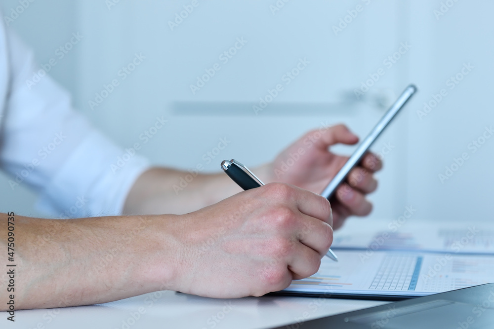Manager checks the statistics on smart phone. Manager checks the statistics on smart phone.