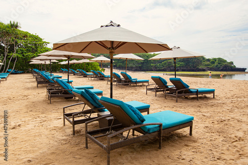 Sun beds and umbrellas on the white sandy beach of Nusa Dua, Bali, Indonesia © Natalia