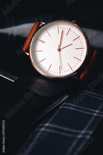 Men's accessories. Stylish watch with a leather strap on a dark background for a businessman