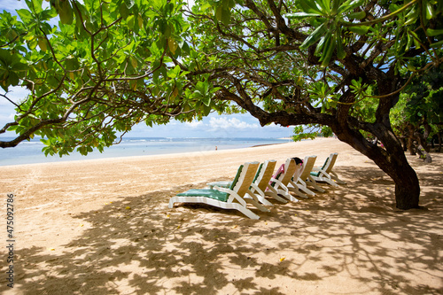 Sun beds and umbrellas on the white sandy beach of Nusa Dua, Bali, Indonesia photo