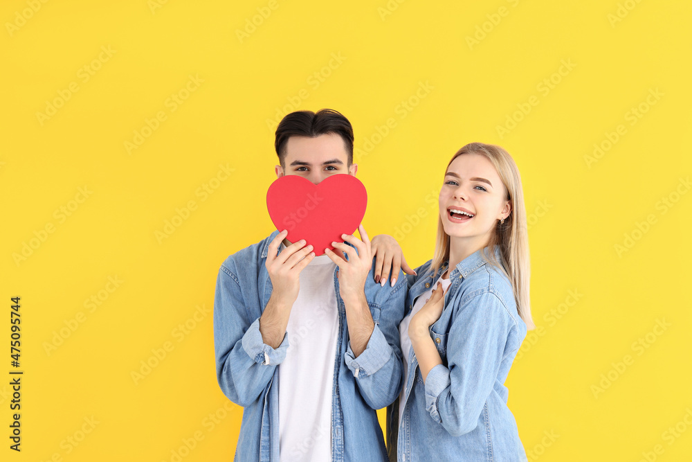 Fototapeta premium Cute couple with heart on yellow background