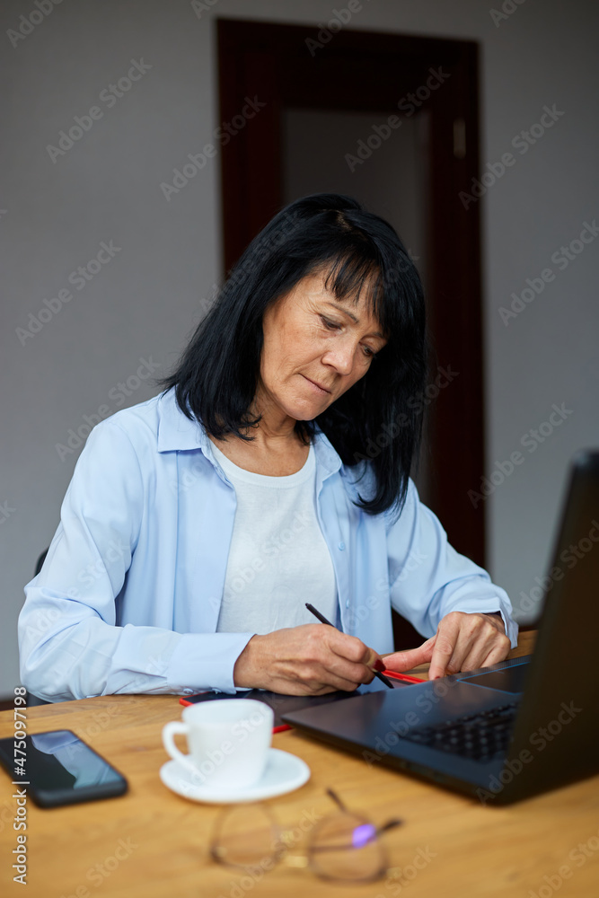 Mature woman designer using graphics tablet and stylus Mature woman designer using graphics tablet and stylus