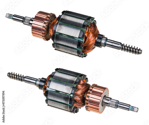 Electric DC motor rotors with copper commutator and coil wire winding isolated on white background. Two engine parts with steel laminations. Worm screw shaft on one side and grooving for fan on other. photo