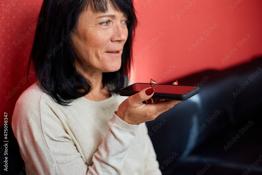 Mature businesswoman freelancer record audio message on smartphone Mature businesswoman freelancer record audio message on smartphone