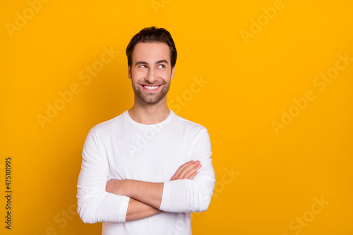 Photo of cheerful glad person folded arms look interested empty space isolated on yellow color background