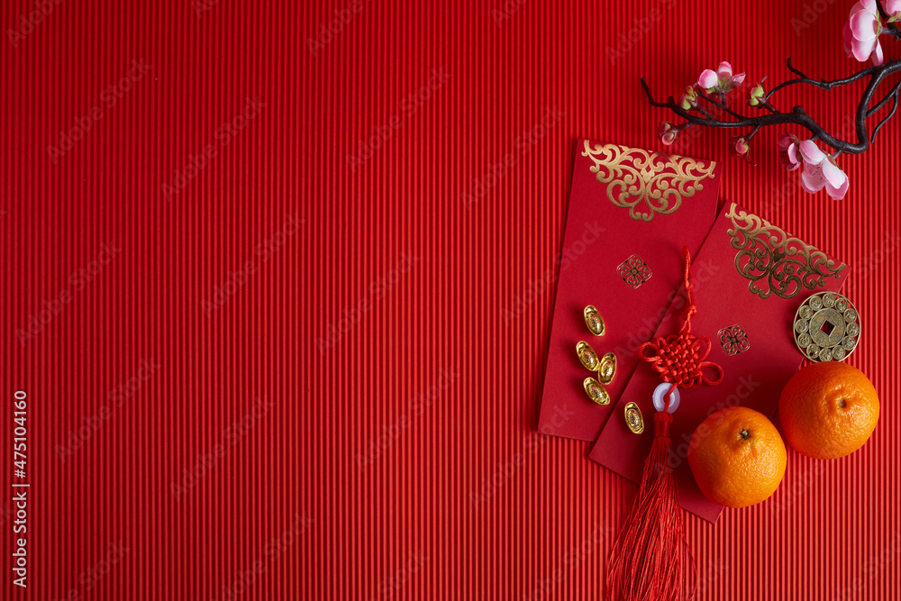 Chinese new year festival decorations. Orange, leaf, red packet, plum blossom on red background.