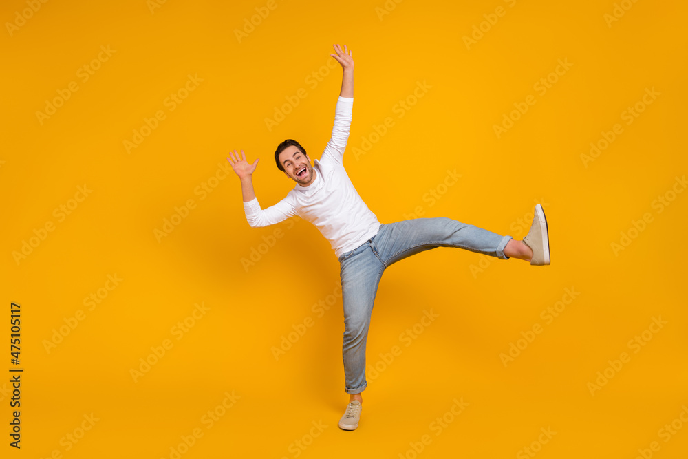 Full size photo of funky brunet millenial guy dance wear shirt jeans footwear isolated on yellow background