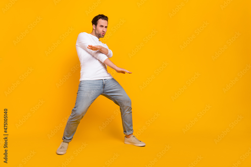 Full body photo of nice brunet young guy dance wear shirt jeans shoes isolated on yellow background