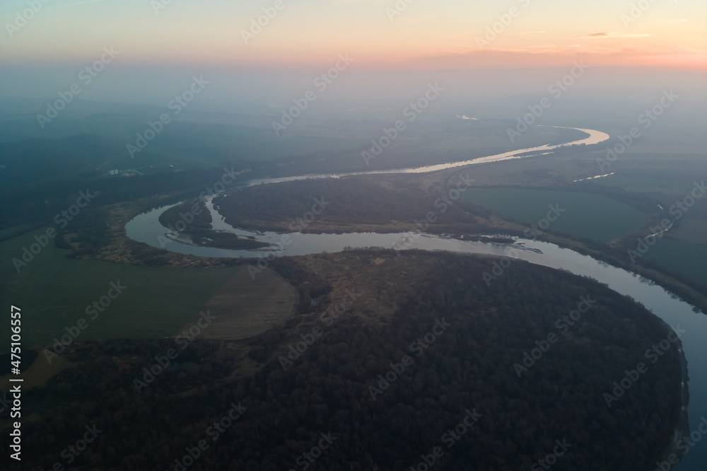 Aerial view of wide river flowing quietly in rural countryside in autumn evening Aerial view of wide river flowing quietly in rural countryside in autumn evening
