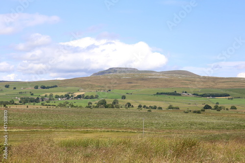 The famous peak of Ingleborough in the Yorkshire Dales National Park surrounded by lush grassland. © George Green