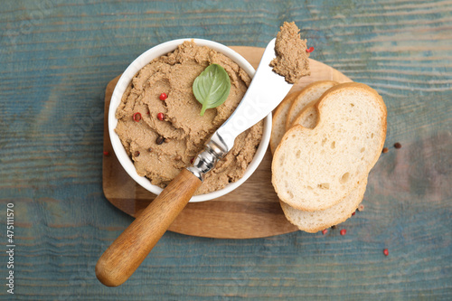 Delicious meat pate with spices, fresh bread and knife on blue wooden table, flat lay