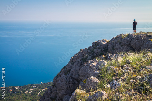 The man standing on the mountain top above the sea
