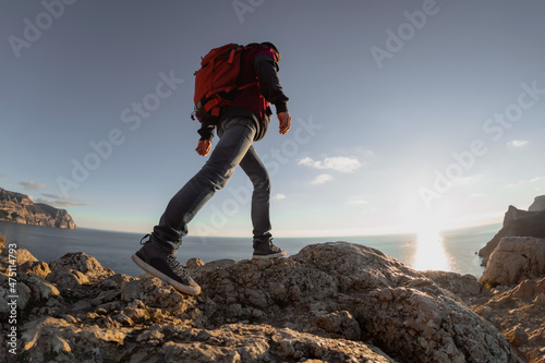Hiker with backpack walk on trek in mountain