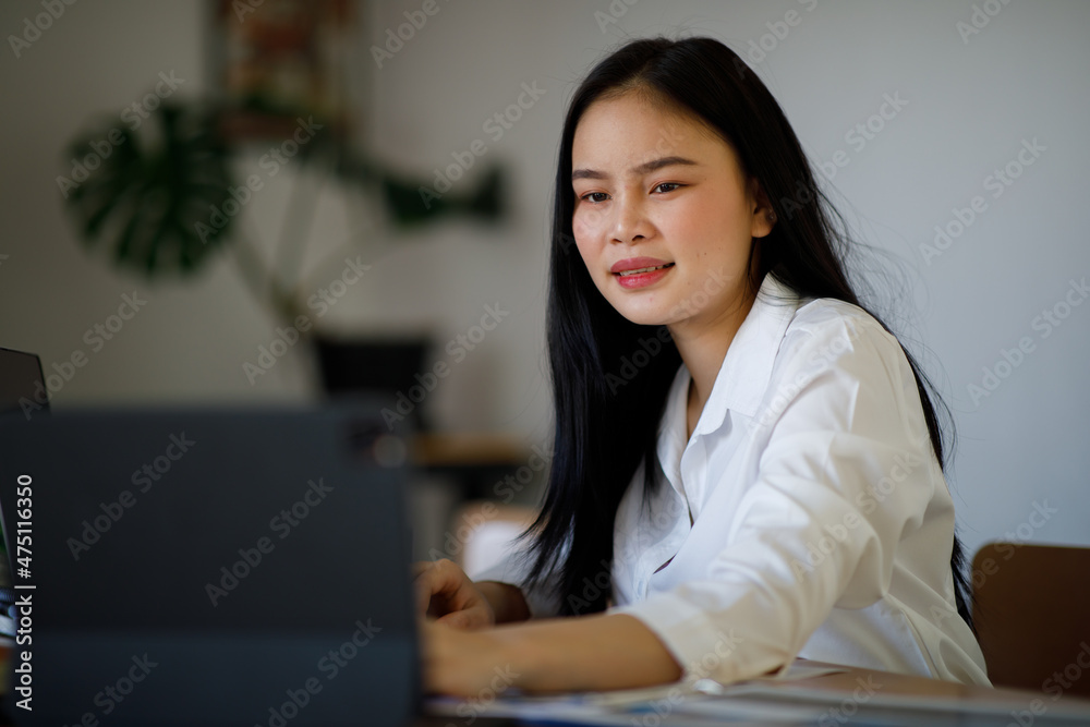 Portrait of Young Asian woman hand freelancer is working her job on computer tablet in modern office. Doing accounting analysis report real estate investment data, Financial and tax systems concept. Portrait of Young Asian woman hand freelancer is working her job on computer tablet in modern office. Doing accounting analysis report real estate investment data, Financial and tax systems concept.