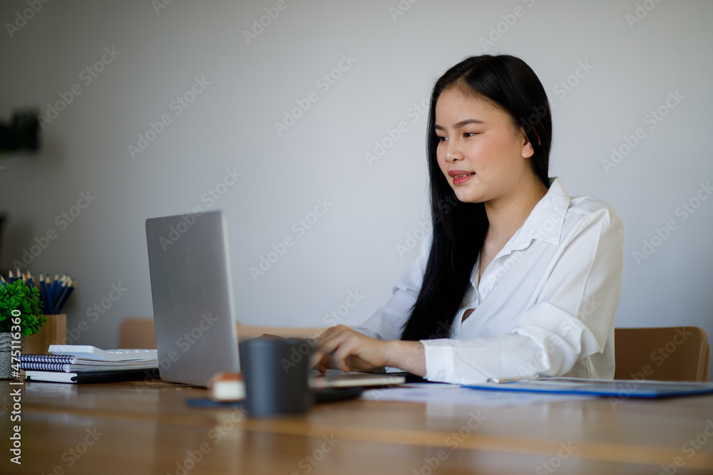 Portrait of Young Asian woman hand freelancer is working her job on computer tablet in modern office. Doing accounting analysis report real estate investment data, Financial and tax systems concept. Portrait of Young Asian woman hand freelancer is working her job on computer tablet in modern office. Doing accounting analysis report real estate investment data, Financial and tax systems concept.