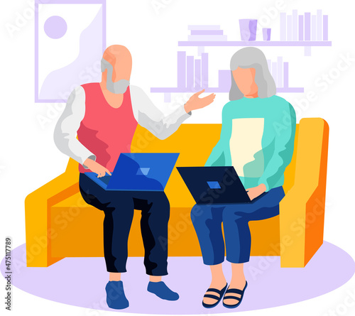 Pair of elegant elderly people are sitting on sofa with laptop or tablet computer. Older people and modern IT technology. Active social life at any age. Help parents-pensioners in education