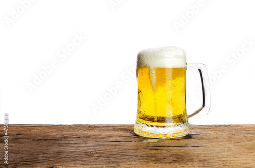 Beer glass with white beer foam on a dark wooden table background