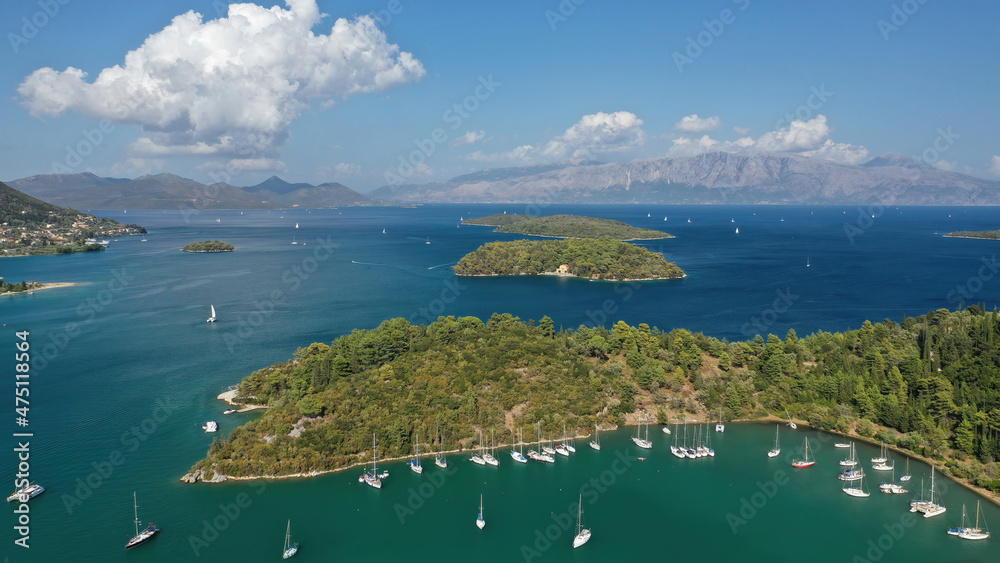 Obraz premium Aerial drone photo of fjord shaped port of Nydri a calm sea safe anchorage for sail boats and yachts famous for trips to Meganisi, Skorpios and other Ionian islands, Lefkada island, Greece
