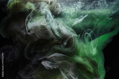 Green smoke on black ink background, colorful fog, abstract swirling emerald ocean sea, acrylic paint pigment underwater